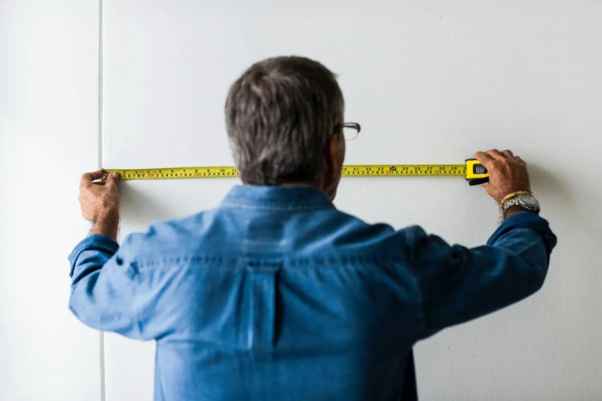 Man Measuring wall using Tape