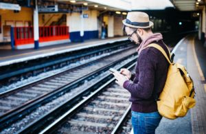 man using phone in railway station