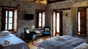 Inside Hotel Room with Bed and Wooden Chairs