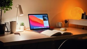 Apple Macbook on the Table with the Open Book