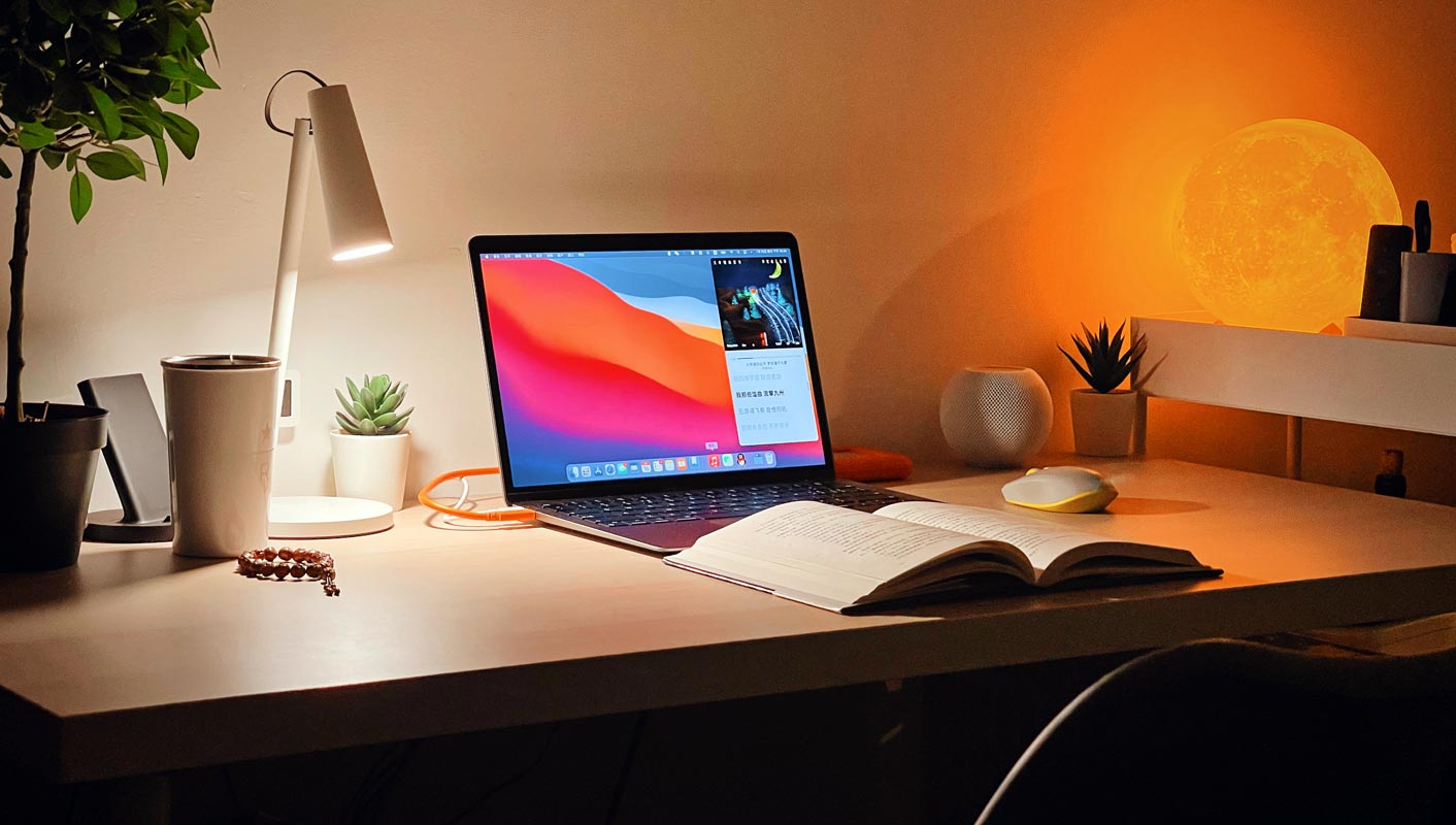 Apple Macbook on the Table with the Open Book