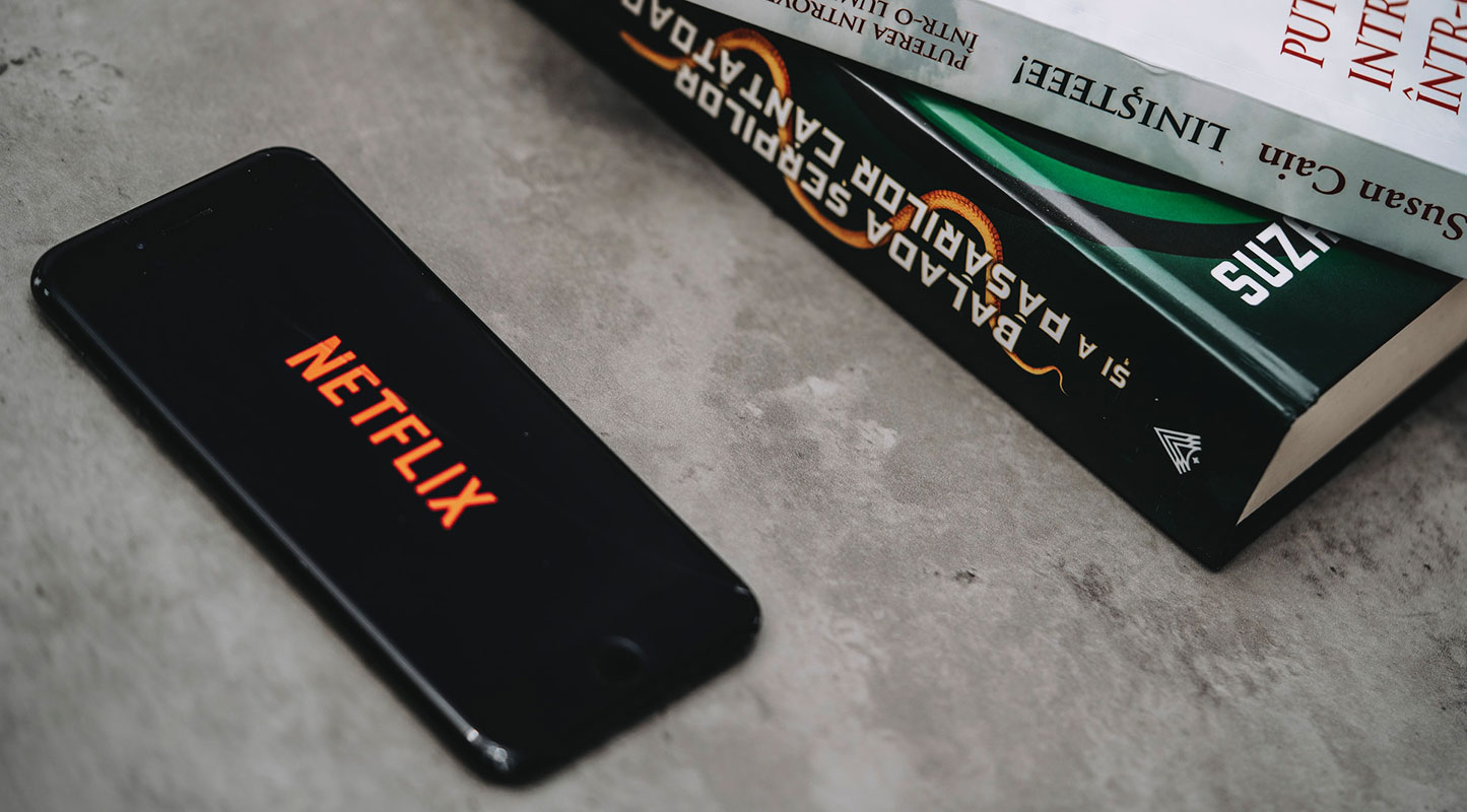 Netflix Logo in Mobile with Books